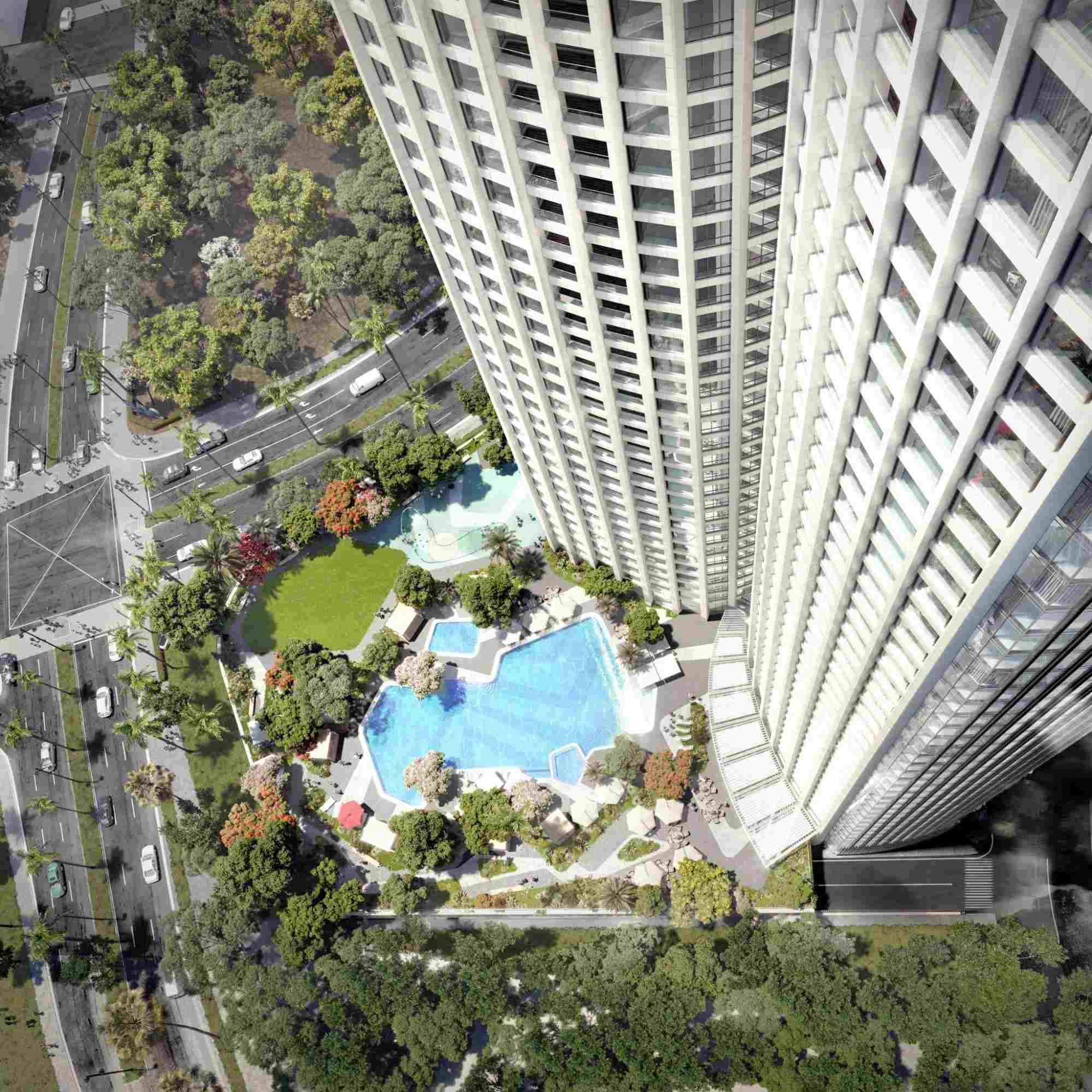 Aerial view of luxury condominium towers with a pool, landscaped amenities, and surrounding greenery in BGC