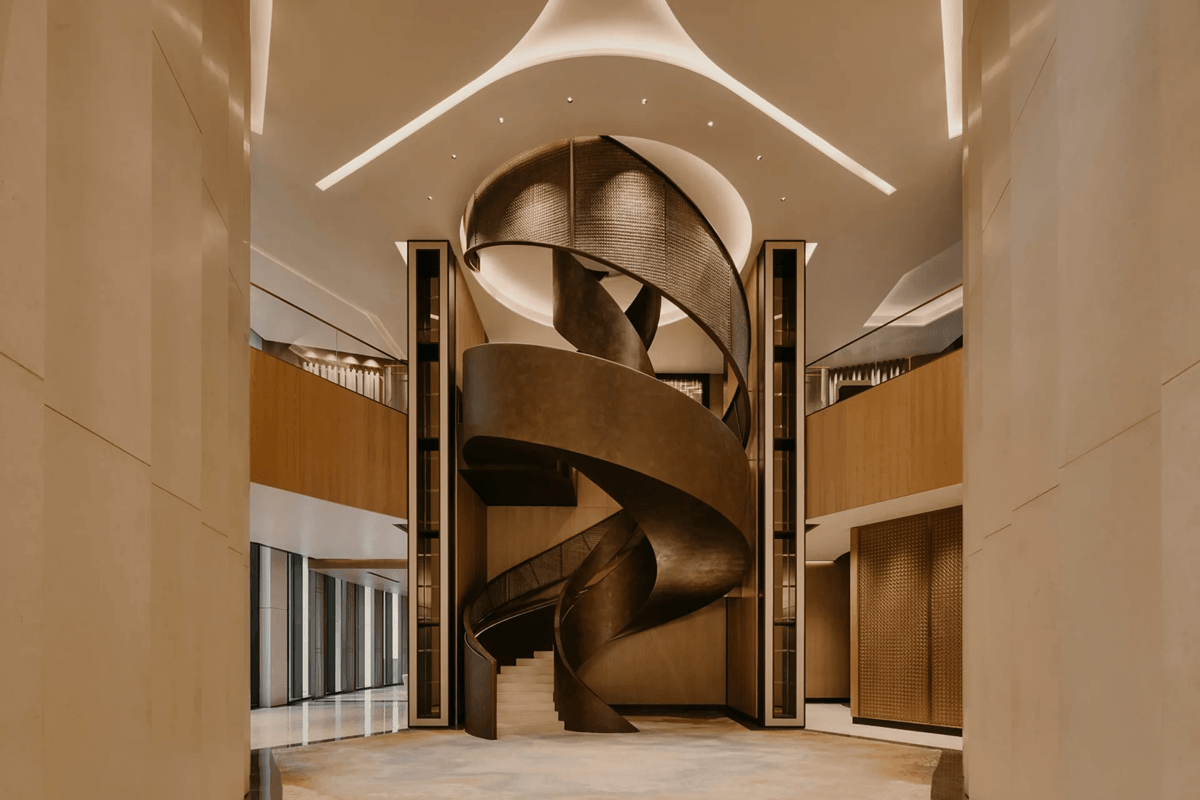 Luxury condominium lobby featuring a sculptural spiral staircase and contemporary architectural design