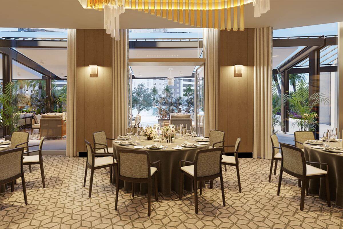 Elegant function room at Aurelia Residences with round dining tables, refined lighting, and views of landscaped outdoor areas