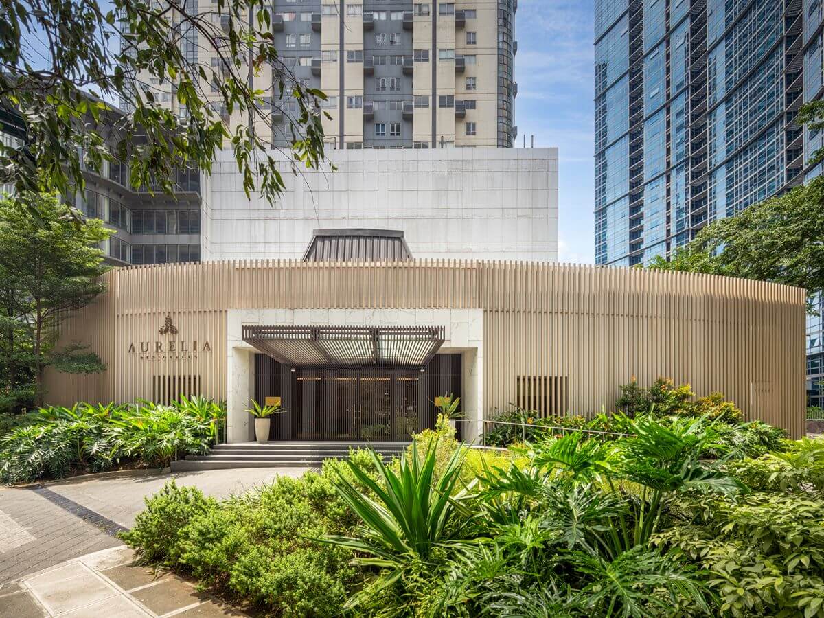 Exterior entrance of Aurelia Residences in BGC surrounded by landscaped greenery and high-rise buildings