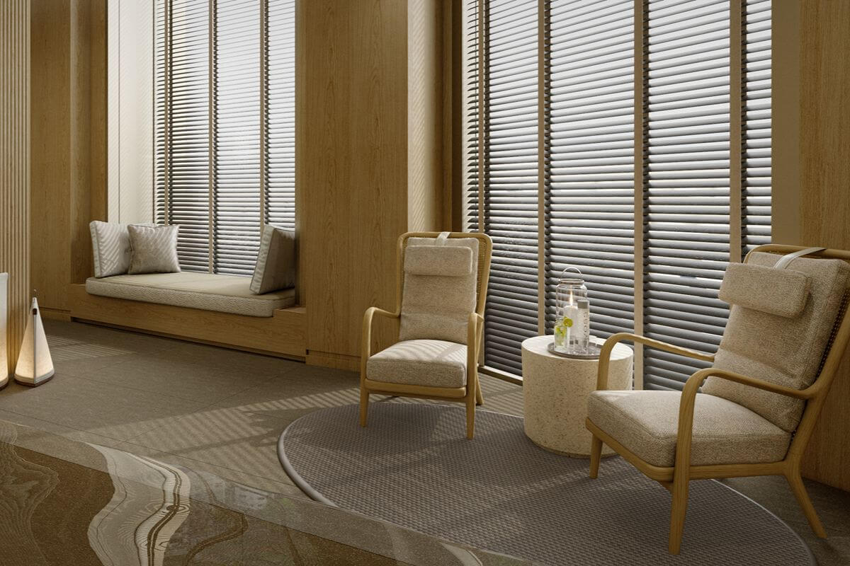 Refined shared lounge with upholstered chairs, a window seat, warm wood finishes, and floor-to-ceiling windows that create a private luxury setting