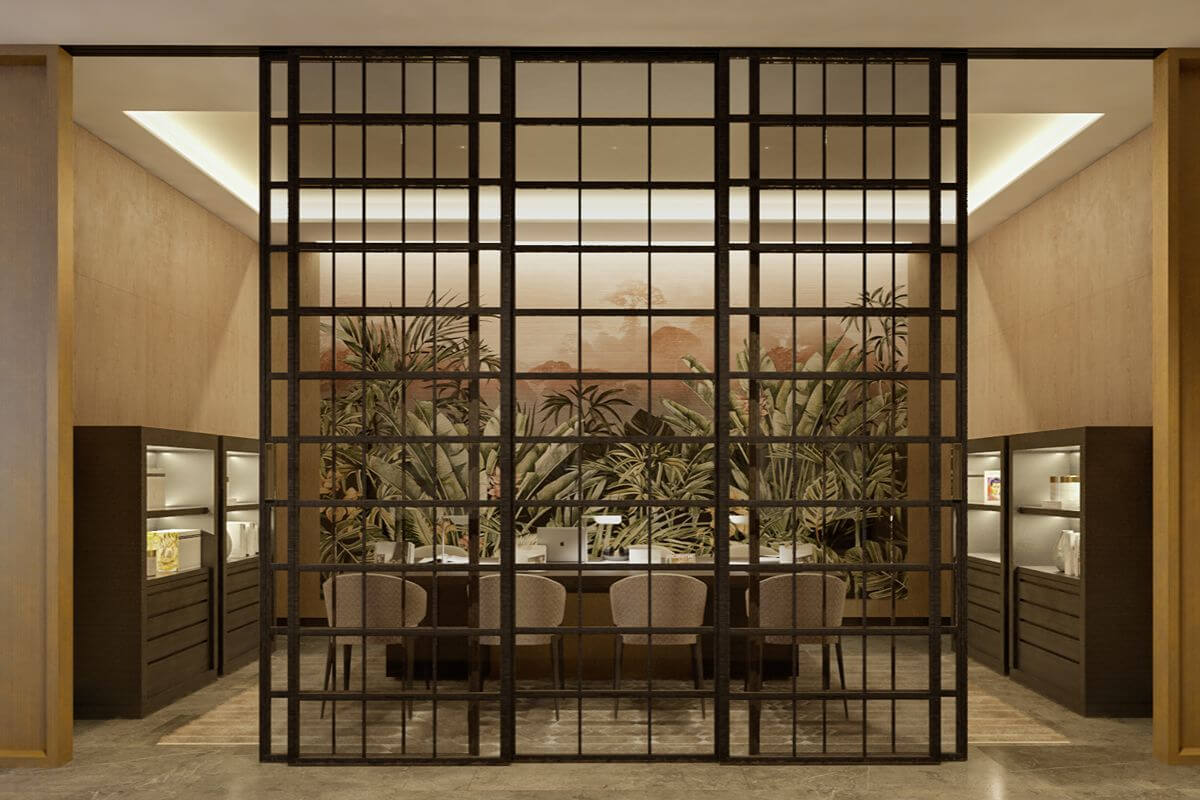 Refined interior lounge framed by a decorative grid partition with seating and landscaped greenery
