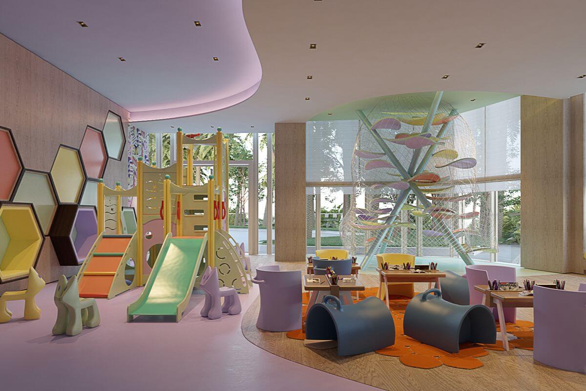 Colorful children’s play area with slides, activity tables, and large windows inside Aurelia Residences